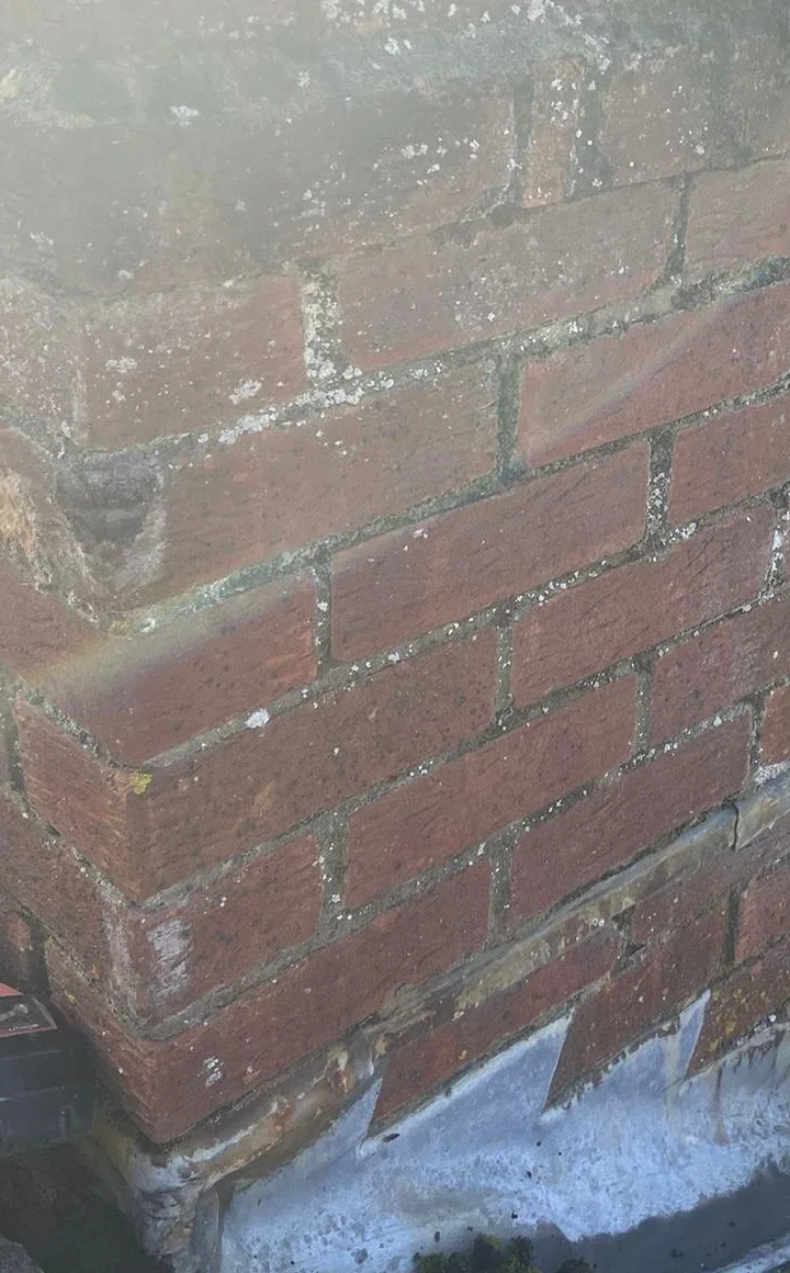 Close view of weathered mortar joints between chimney bricks