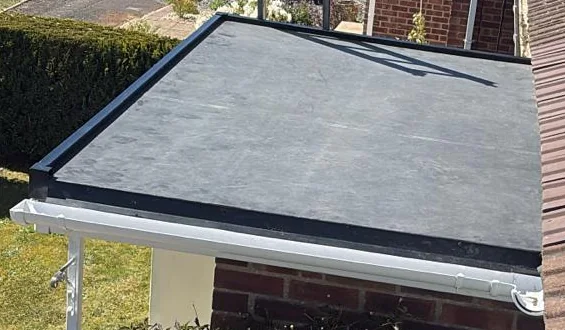 Dark flat-roof covering with perimeter edges above a porch