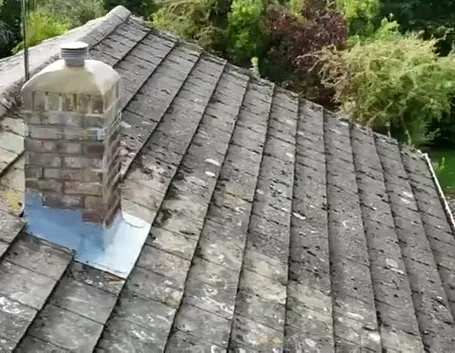 Brick chimney with mortar joints, shaped top mortar and lead flashing at the tiled roof