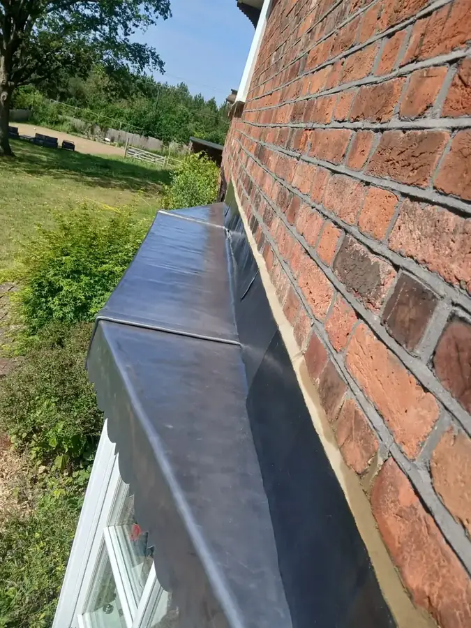 New lead bay roof dressed against brickwork in Upminster, Essex